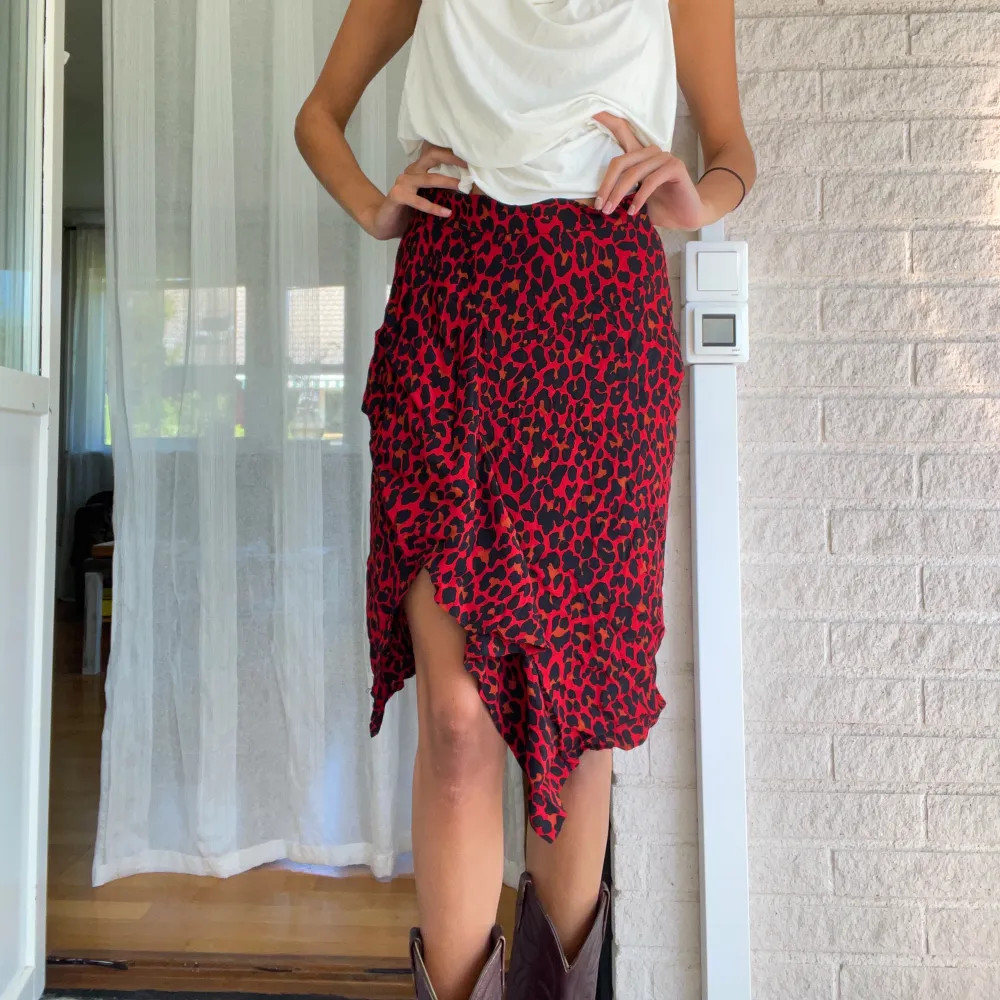 En leopardmönstrad röd kjol köpt på zara för några år redan! Den har en slits och volanger! sitter midwaist och har en dragkedja på sidan! Storlek M! Jag är 178 cm!. Kjolar.