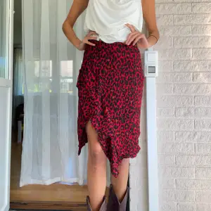 En leopardmönstrad röd kjol köpt på zara för några år redan! Den har en slits och volanger! sitter midwaist och har en dragkedja på sidan! Storlek M! Jag är 178 cm!