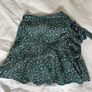 Söt och vacker kjol med justerbar knytdetalj! Fin grön färg med vita blommor💫 knappt använd och bra skick☺️