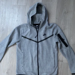 Nike Tech Fleece - Grå Nike Tech Fleece, 9/10 Skick Använd kanske 10 gånger max, säljer den då den blev för liten. Nypris 1349 kr