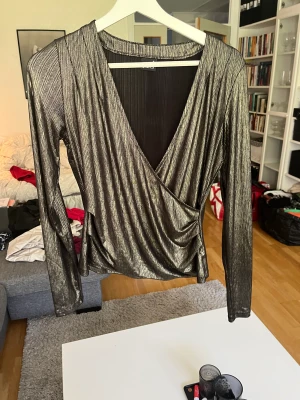 Blus - Blus till fest, guldig och svart. Är i fint skick förutom att armbågarna har tappat lite färg på armbågarna. Se bild