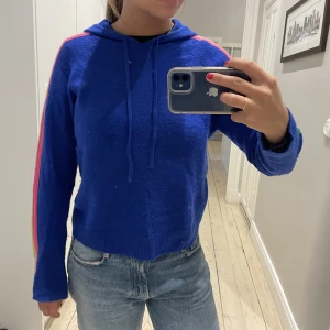 Charsmire hoodie blå - Charsmire hoodie från from future i en sån härlig blå färg med färgglada räder på armarna. Den är i storlek S och så skön nu till hösten.