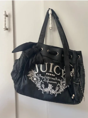 Juicy couture väska - Säljer denna fina svart juicy couture väska. Den är äkta.  Den är stor  får plats med mycket! Säljer då jag köpte en annan och använder den inte och behöver pengar!😊