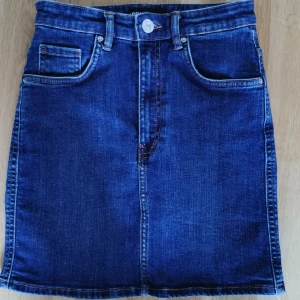 Mörkblå jeanskjol från Zara - Mörkblå jeanskjol från Zara med snygg passform. Färgen syns bäst på sista bilden. Fint skick! 