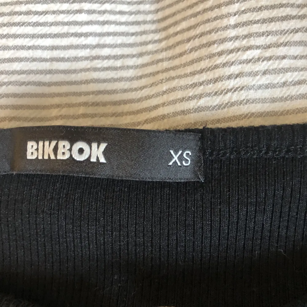 Långärmad ribbad tröja från Bik bok i strl XS men passar även S, använd ett fåtal gånger men inget som syns, hål ovanför brösten med gulddetalj. Toppar.