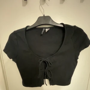 Svart topp - Svart topp med snörning från hm. Köparen betalar för frakten