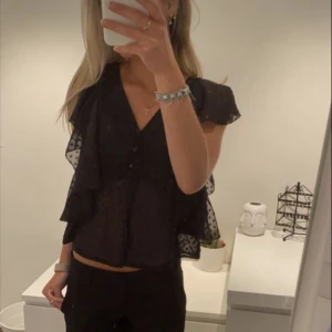 Svart volangtopp med knappar - Säljer denna jättegulliga toppen från bik bok. Lappen är dock avklippt men det är samma modell som en topp jag sålt tidigare fast bara en annan färg❤️