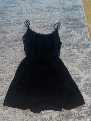 Svart lace klänning  - Svart klänning med lace på sidan