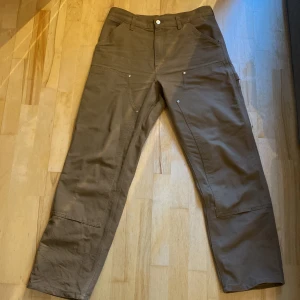 Carhartt Dubble-Knee - Ett par bruna carhartt byxor i 9/10 con. Knappt använda. Bara att komma privat för frågor.