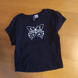 Svart t-shirt med fjäril, endast använd 1 gång super fint sckick.