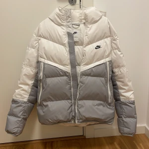 Nike vinterjacka  - En Nike vinterjacka i nyskick säljes.  Storlek M. Vit och grå. Välldigt bra inför en kall vinter.  Ordinarie pris  2395kr säljes för 1100kr. Prutat och klart. 