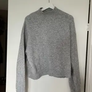 En stickad grå tröja från h&m, storlek s, lite högre krage 