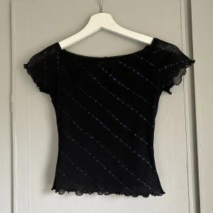Söt vintage Topp! - Kortärmad vintage svart topp med blåa glittriga detaljer! Storlek xs/s! Använd köp nu funktionen💋