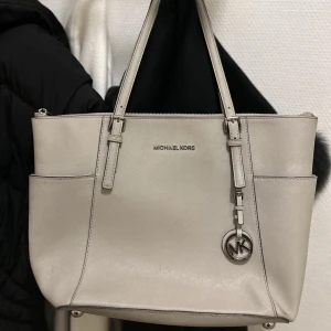 Michael Kors väska  - I använt men fint skick, med viss märkbart slitage samt några fläckar på insidan. Nypris ca 2.000:- 