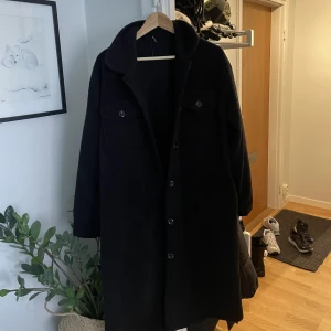 Jacka - En svart knälång jacka passar M/L är lite oversize. Aldrig använd pga fel storlek.