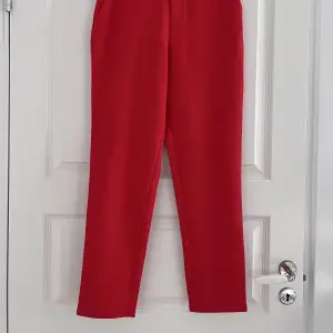 Röda kostymbyxor från Nakd. Endast använda ett fåtal gånger och är fortfarande i väldigt fint skick!!  Midjemått: ca 70 cm