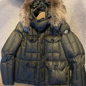 Äkta moncler jacka - Äkta Moncler jacka i Olivgrön färg,  VION GIUBBOTTO VION JACKET  Nypris runt 14k därav bara pälsen gick på över 2k som var beställd i efterhand.  Strl 2 Man, men funkar som unisex också  Inga fel eller slitningar på den. Dock ena innelappen är borttagen/t