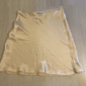 Siden kjol  - Kort siden kjol med resår i midjan. Vit/Beige/rosa färg 