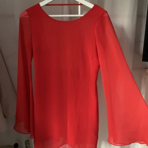 Röd klänning  - Superfin klänning med breda ärmar och öppen rygg 