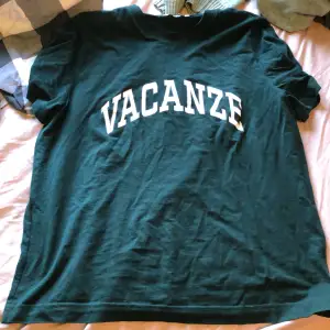 En grön t-Shirt med en text som det står VACANZE