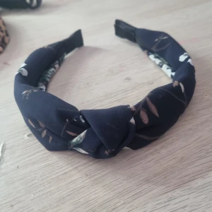 Diadem  - Ett mörkblått diadem jag aldrig användit! Det är blommer på diademet!