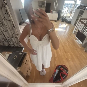 Vit klänning  - En supersöt vit flowy klänning som är rosett formad vid bysten och ca knälång på mig som är 165cm❤️ Klänningen är i storlek S/36 men skulle säga att den är stor i storleken och passar även M. Säljes pga för stor och är därför knappt använd❣️