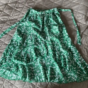 Omlottkjol - Grön omlottkjol med vita blommor/ prickar. Knytbara band.