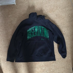 Blå hoodie med gröna tryck - Säljer denna då den har tvättats några gånger vilket skedde till att den har krympt. Går knappt att ha på. Den är XL men känns som L