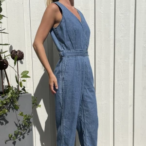 Jeans jumpsuit - En jumpsuit i jeans med dragkedja därbak, och en dold knapp vid vringningen så man kan öppna till en djupare vringning.