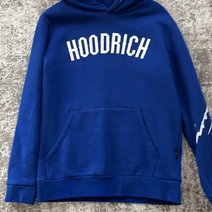 Blå/mörk blå Hoodrich Hoodie. - Denna Hoodien är i helt nytt skick använd ett par gånger. Storlek S men passar även som storlek M. Hoodrich som är ett väldigt populärt märke bland ungdomarna just nu.