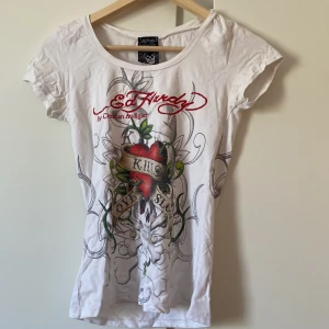 Ed Hardy t-shirt - En vit t-shirt från Ed Hardy, med ett fint tryck med texten  ”love kills slowly” 💃🏼  Har även tryck på baksidan!  Står ingen storlek men skulle uppskatta till en xs/s men har stretch så passar nog även M🌸   Fint men använt skick ✨