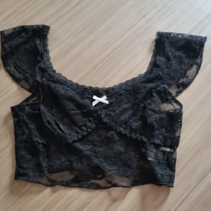 Topp - En fin genomskinlig topp som går strax under brösten. Sparsamt använd