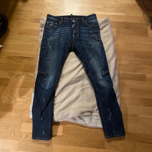 Dsquared Jeans strl 46 - Ett par fräscha Dsquared2 Jeans, använda ett tiotal gånger men i toppskick. Nypris ca 4500kr Storlek 46 och passar mig som är 192cm.  Kvitto finns ej då jag köpt av en vän men kan skicka bilder på detaljer för att visa att de är äkta.