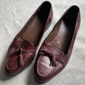 Bruna loafers  - Ett par äldre (välskötta) loafers med tofs. Passar en större 38a i stlk. Fin och relativt ny sula.