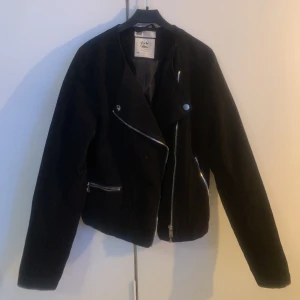 Sommarjacka i mocka-imitation - Jackan har silverdetaljer och är lite lång i armarna på mig som är 160cm lång.