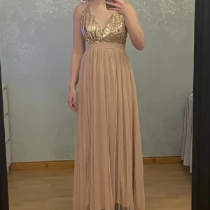 Klänning - Klänning med paljetter och öppen rygg med dragkedja bak. Den är inte mer än testad då jag hittade en annan klänning. Pris kan diskuteras