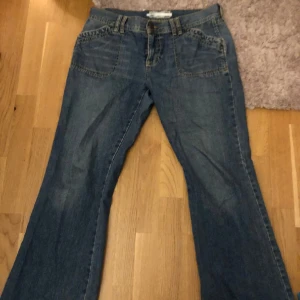 Lowwaist bootcut jeans  - Coola lowrise jeans som är bootcut, sitter lite baggy på mig och har därför satt ett snöra i midjan så man kan knyta åt. Går även att ta ut smöret och det syns oavsett inte om man har det i. Osäker på storleken men är lite stora på mig som har 28 i waist.