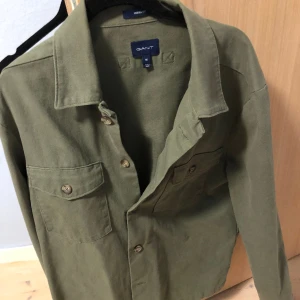 Overshirt  - En riktigt fin knappt använd overshirt från gant i storleken M. Inga defekter använd cirka 3 gånger. Passar perfekt för någon mellan 180-187cm. Nypris 1700kr mitt pris 500kr
