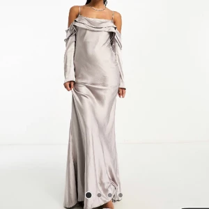 Balklänning silver/grå - Strl 38, sitter väldigt bra och formar kroppen. Säljes då den inte längre kommer till användning, använd en gång. Har tyvärr inte bättre bilder, utan endast screenshot från video när jag testade den på första gången. Kan skicka mer vid intresse.