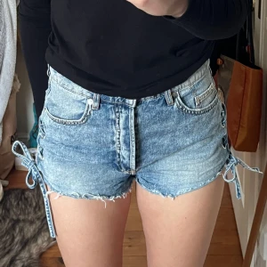 Jeansshorts H&M - Snygga jeansshorts ifrån H&M med knytdetaljer i sidan. Strl 38 Hör gärna av dig vid frågor😊