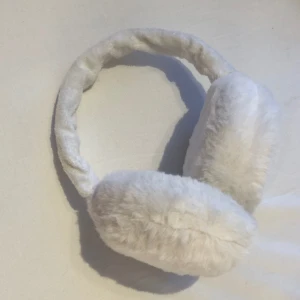 VITA FLUFFIGA ÖRON MUFFAR - Hejsan! Säljer mina jätte söta öronmuffar i vitt fluff. Perfekta till vintern, nyskick men säljes då jag tror att jag endast kommer att använda mössor i vinter. Super mjuka och fluffiga som värmer jättebra. Utmärkt praktiska då man kan justera storleken💕💕