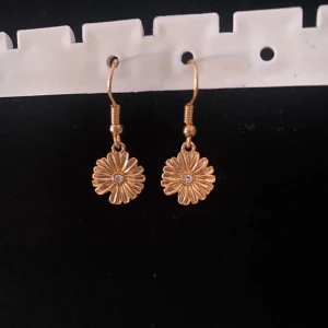 Örhängen  - Ett par örhängen med blommor på (handgjort). När du köper så kommer 20% av pengarna gå till Cancerfonden.  När du köpt så kommer du få bildbevis på att vi skänkt pengarna till Cancerfonden. Hör av dig till oss vid funderingar.