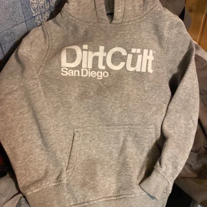 Dirtcult Hoodie - En Dirtcult luvtröja som barnet har växt ur.  Tyvärr saknas snören i luvan.  Hoodien är i gott skick. 