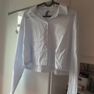 Cropped skjorta från HM - Säljer denna gulliga croppade skjorta från HM🩵 Den är vit med ljusblå ränder🩵 Storlek M, passar även S🩵