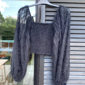 Festblus  - Super söt festblus i svart med delvis genomskinliga armar och svagt glitter.  Perfekt till fest eller nyår mm. Kommer från BikBol och är väldigt sparsamt använd. 🖤