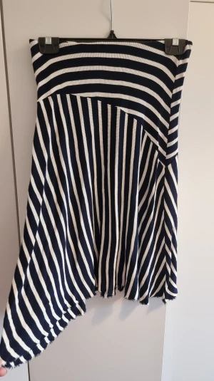 Randig stickad kjol från Mango - Knälång randig stickad kjol från Mango. Mörkblå / ljusbeige. Storlek S