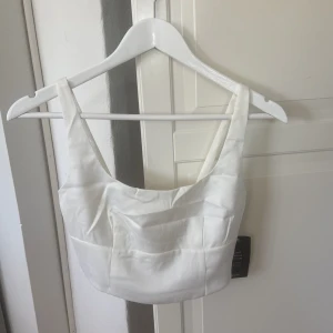 Vitt linne i satin - Vitt linne i satin med fyrkantig skurning. I strl 34. Aldrig använt.