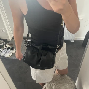Svart väska  - Svart väska med snurrad band säljes. Justerbar hur lång man vill ha den. Gott om utrymme i väskan och i väldigt bra skick . Köptes på zalando från märket Defacto för 213kr