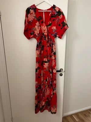 Klänning från yas - Röd klänning med blommor på, storlek S. Endast använd ett par gånger