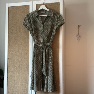 Ljusgrön klänning - Ljusgrön klänning från Kappahl, storlek 42 (men skulle säga en S). Säljes pga för liten för mig som oftast är storlek M  Knappar hela vägen framtill & knytband i midjan   Köparen står för frakt. Kan mötas upp i Stockholm/ Vällingby/Kista